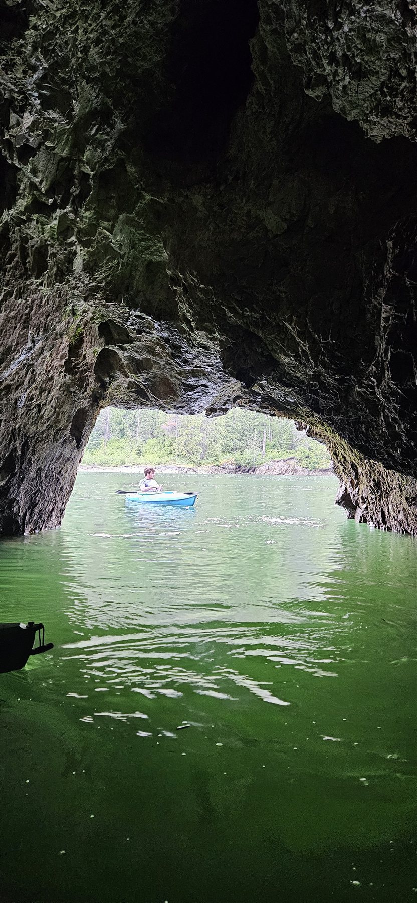 Kayaker paddling through a cave opening on the river
